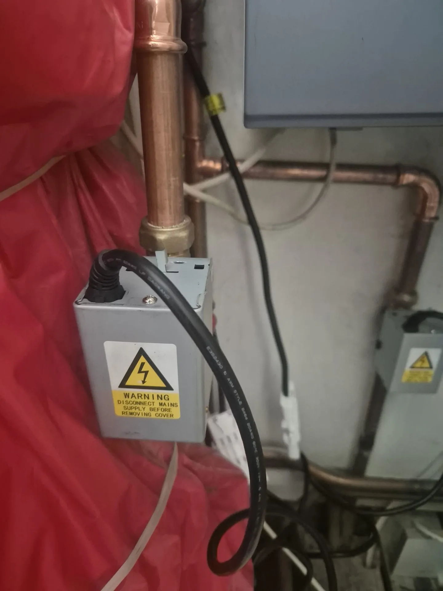 Heating engineer fitting a motorised valve on central heating pipework in Romford
