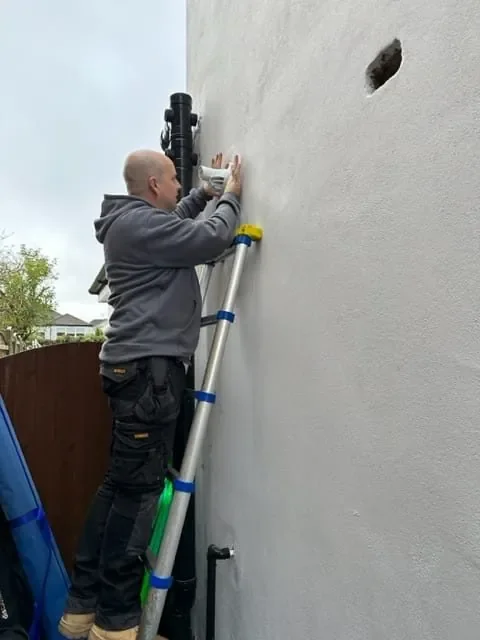 Engineer working on an external boiler flue