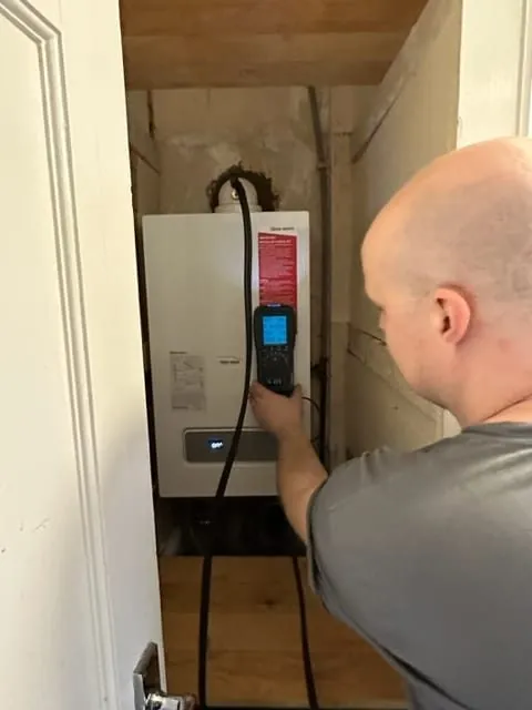 Gas Safe engineer testing a boiler with a flue gas analyser in Romford