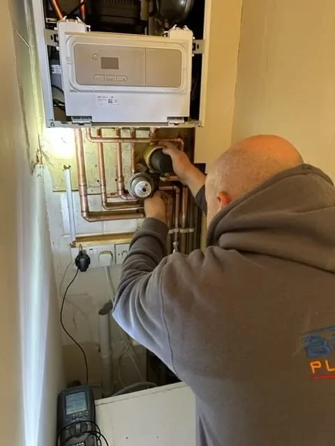 Engineer working on a boiler and its copper pipework
