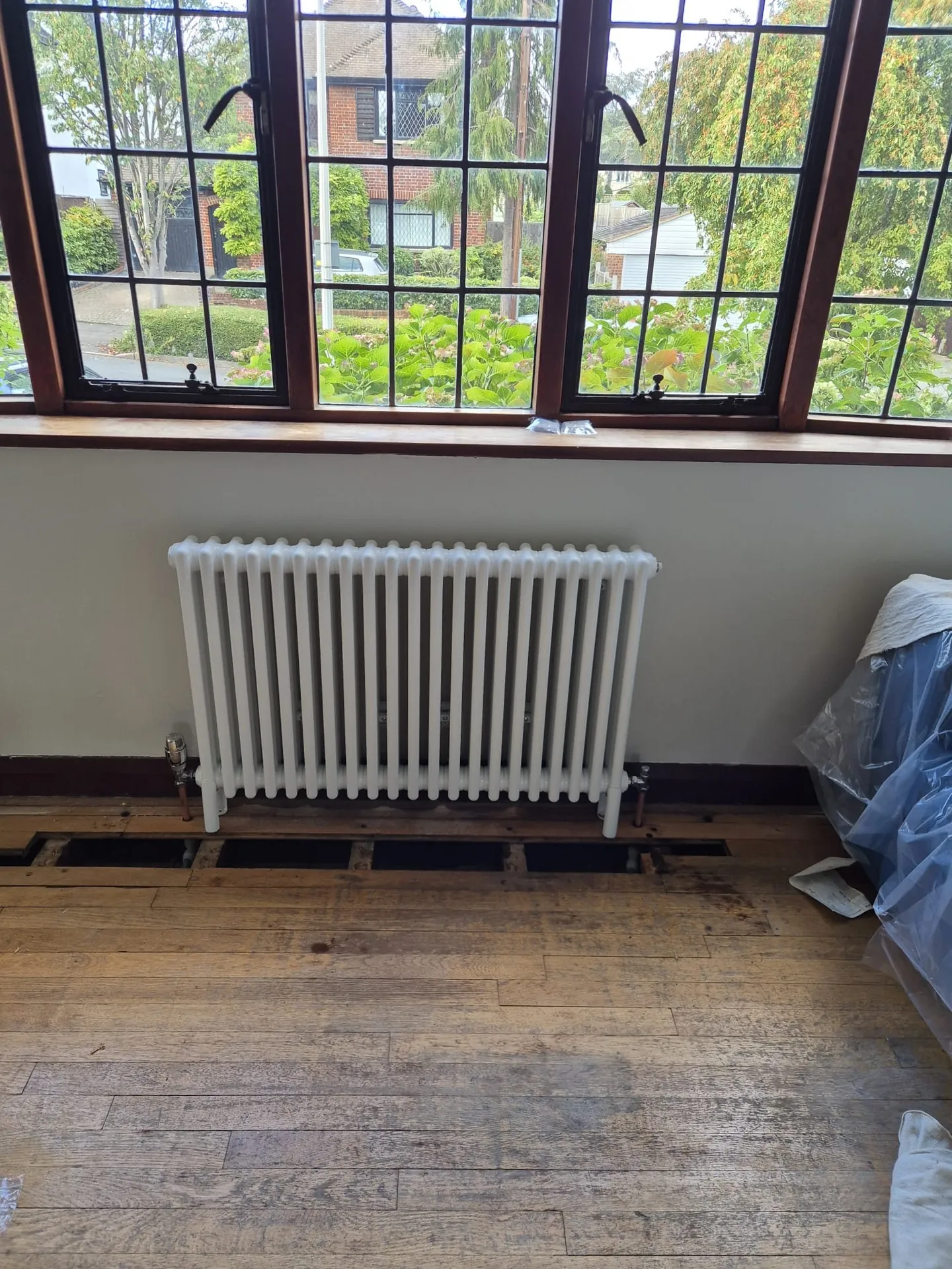 White column radiator installed under a window in Romford